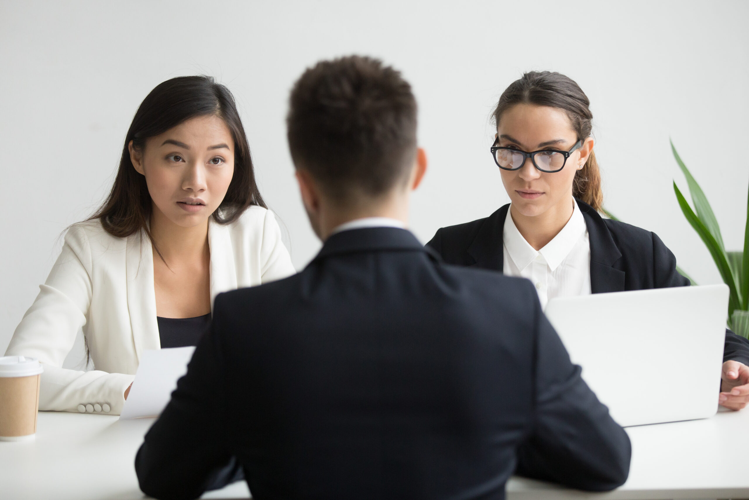 Serious unconvinced diverse hr managers interviewing male job applicant, doubtful strict female recruiters looking uncertain distrustful rejecting vacancy candidate, bad first impression concept