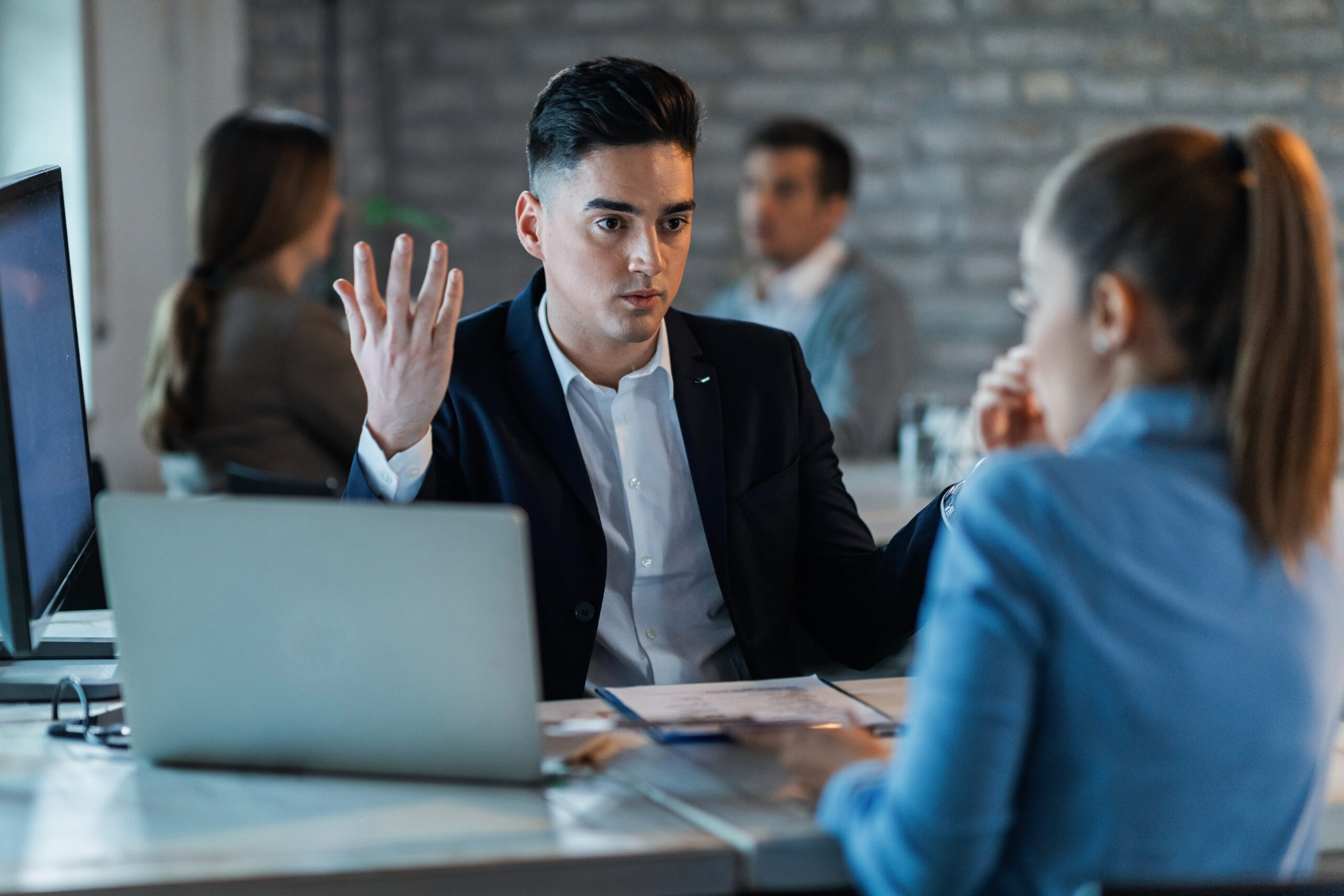 Frustrated businessman discussing with his female colleague while having a conflict in the office.