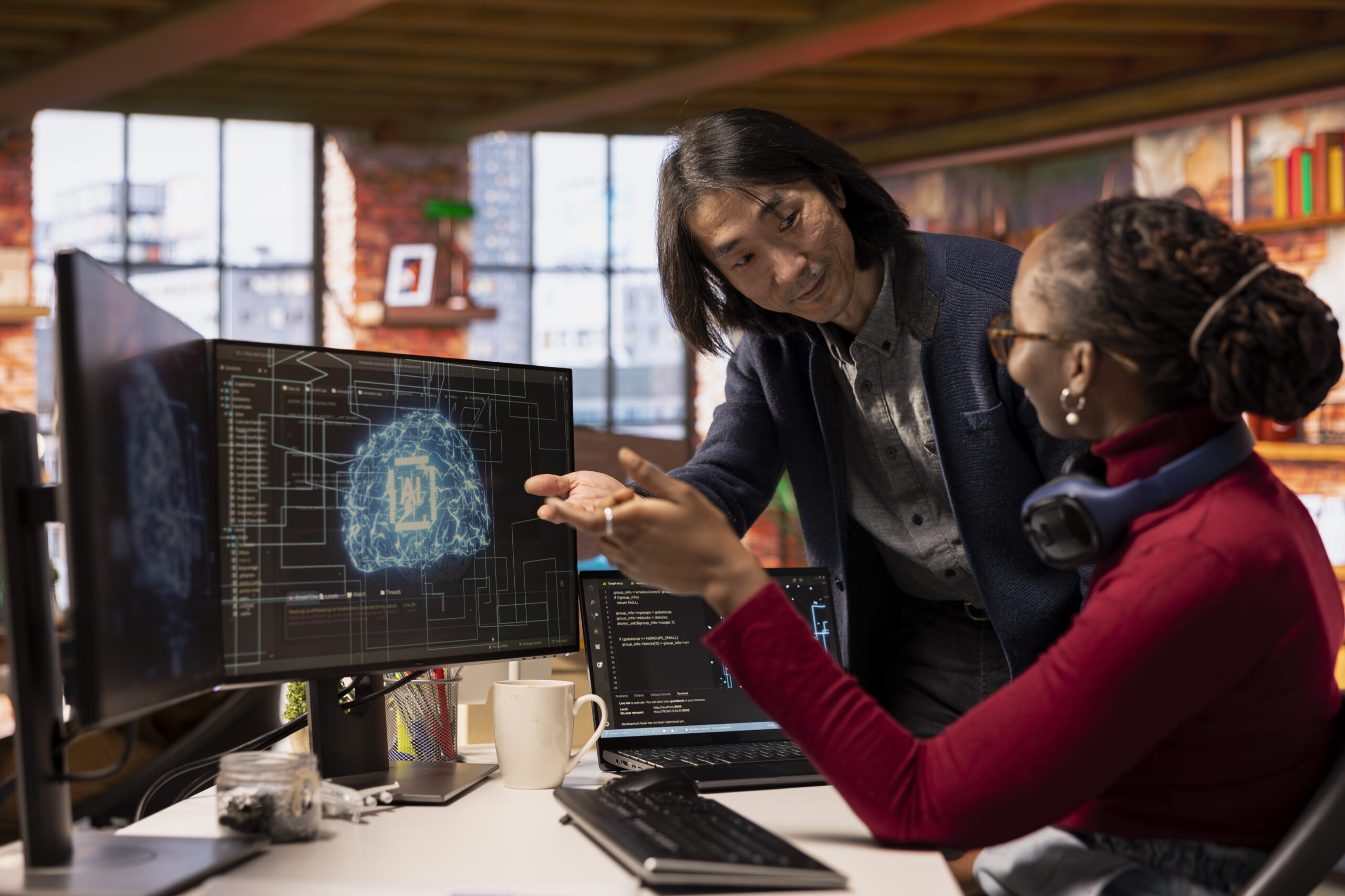 Manager and technician discussing coding in office