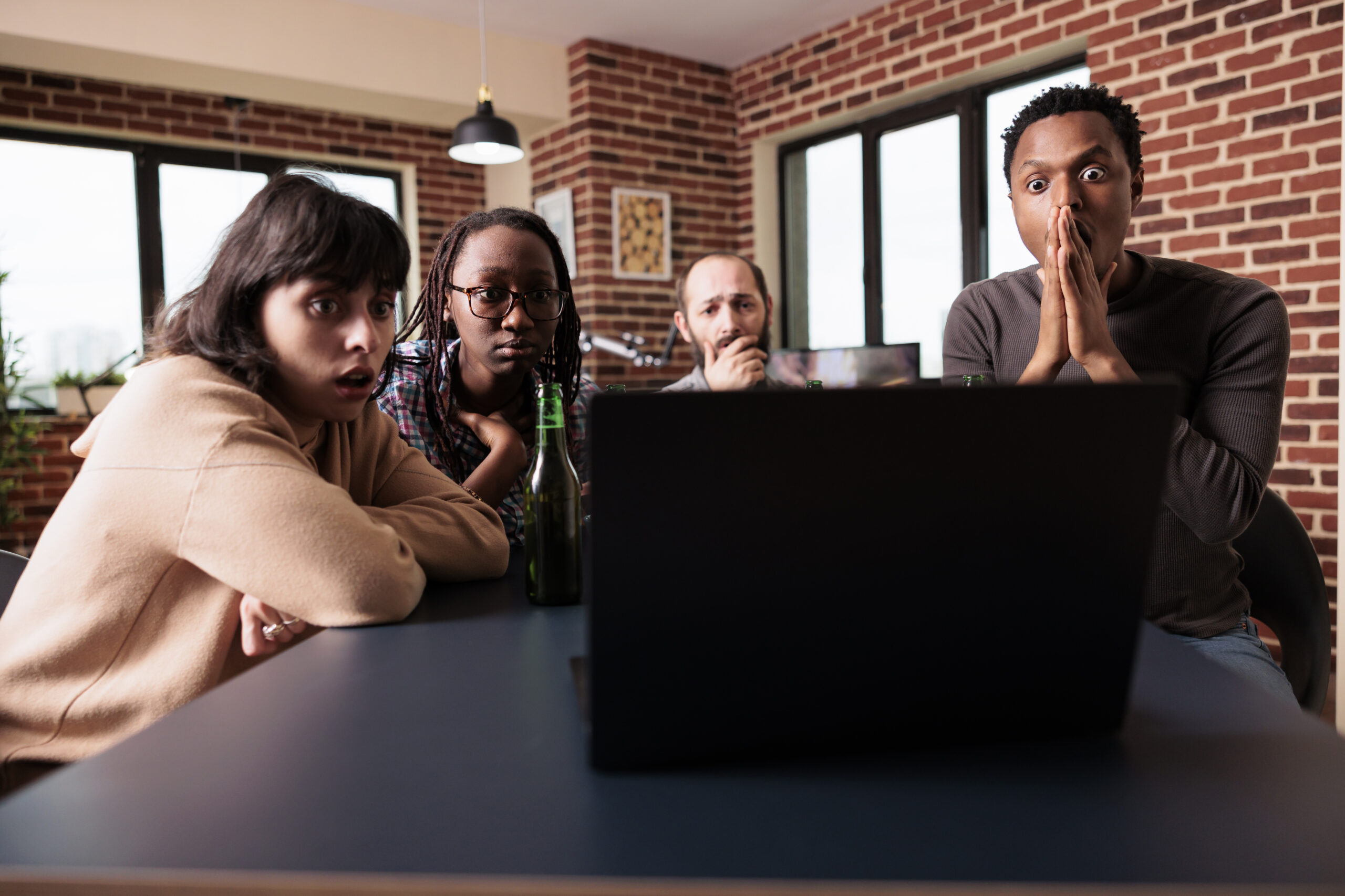 Worried coworkers in office shocked at laptop screen