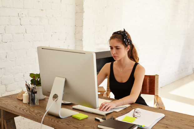Upset female looking at a screen while working at a desk.